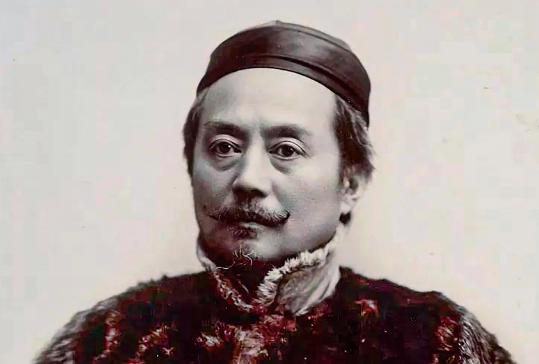 1871年，德国的一辆火车上，辜鸿铭手拿报纸，倒着在看。两个德国青年指着那个