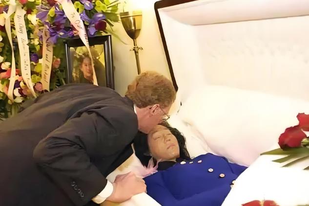 这是张纯如最后的遗容，她安详地躺在棺椁里，丈夫亲吻她的额头，与她做最后的告别，她