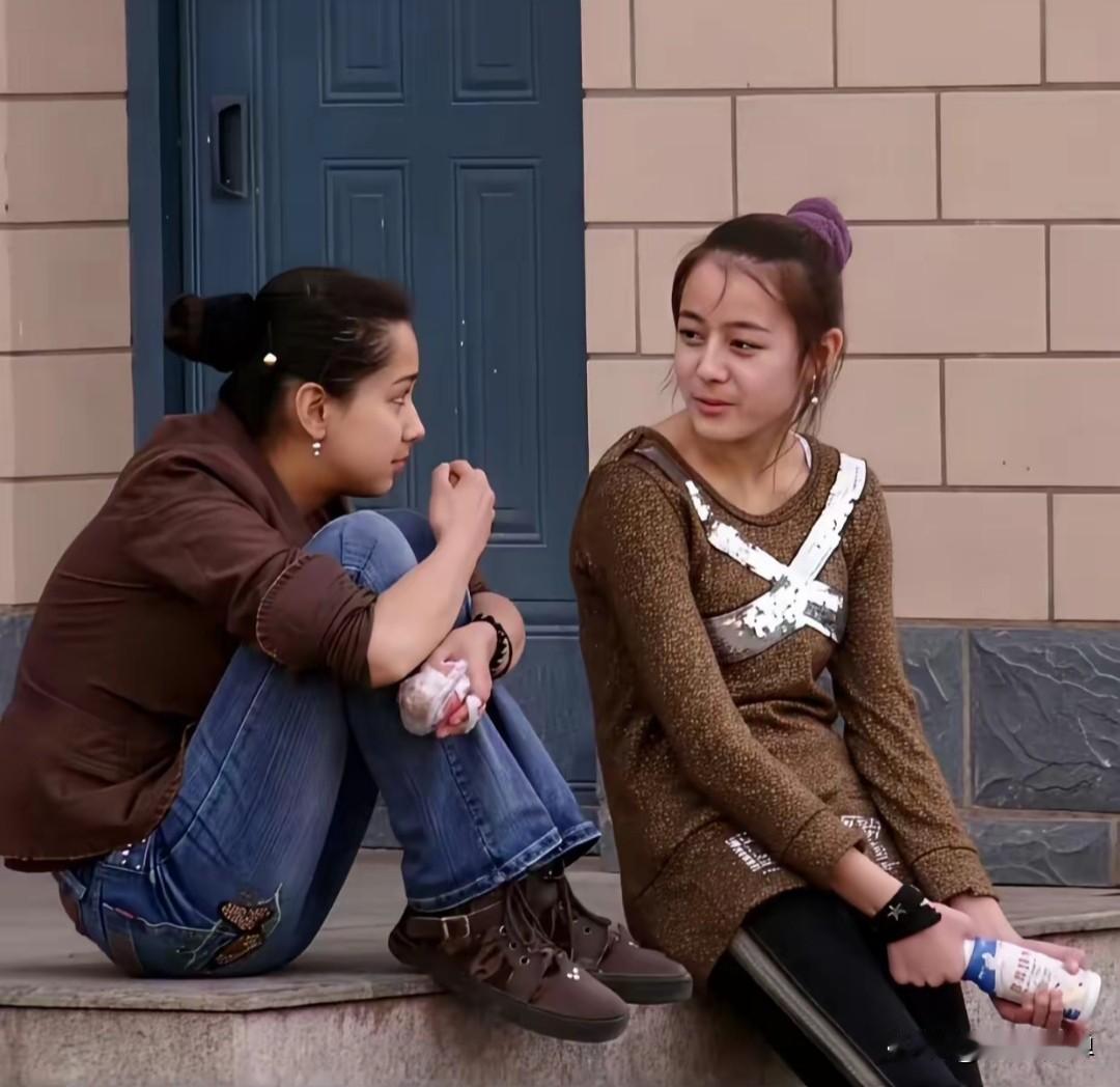 2007年，新疆布尔津汽车站，一个15岁的女孩和朋友坐在台阶上聊天说笑，手里攥着