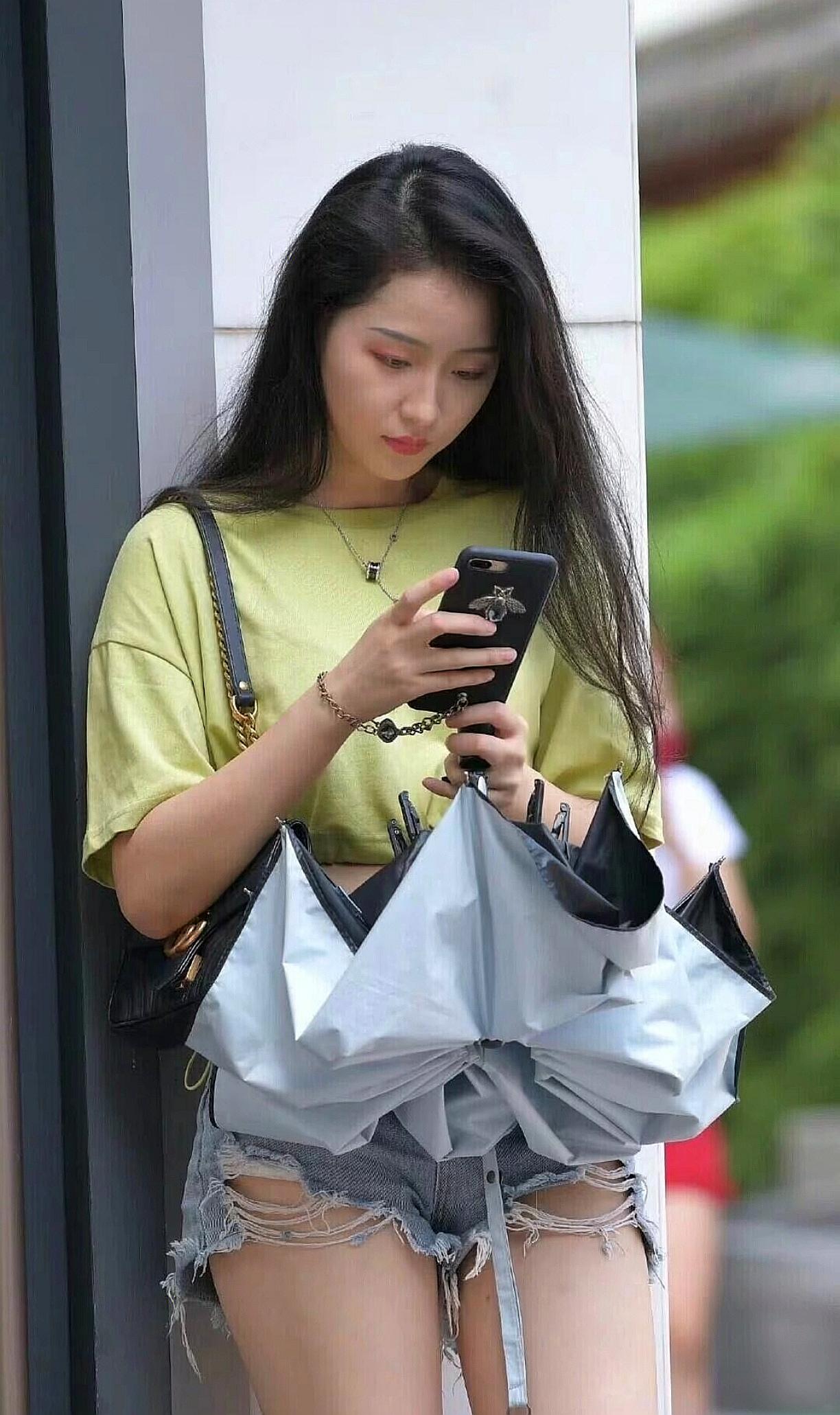 一个女孩在街上看手机。