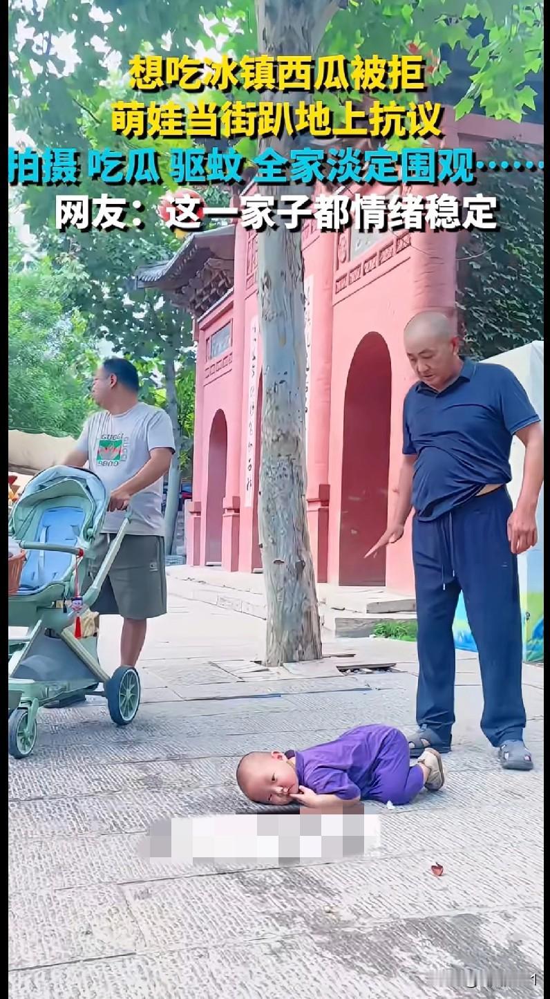 “家人们谁懂啊！这娃为了口吃冰镇西瓜，当街趴地‘抗议’，全家反而淡定围观，拍照的
