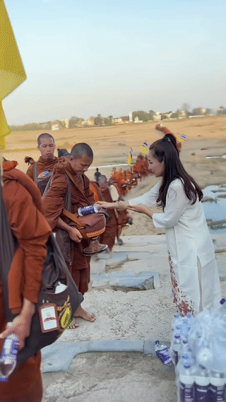泰国🇹🇭一位善良的年轻美女站在路边免费给一队正在进行徒步苦行的僧团免费发放纯