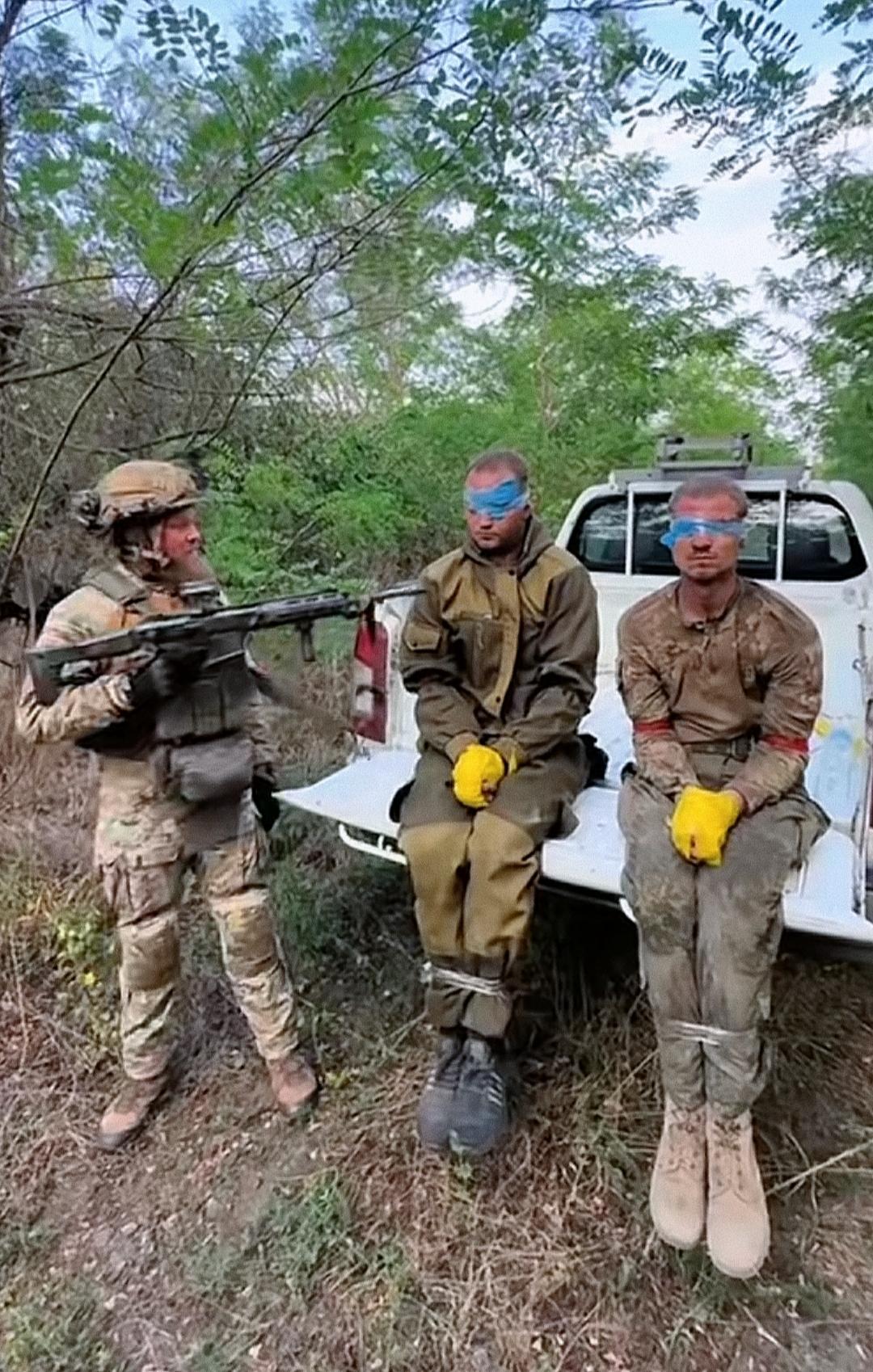 一个大胡子士兵抓了俩名俘虏，并用类似于塑料胶带的东西困住了他们的手脚，蒙住了他们