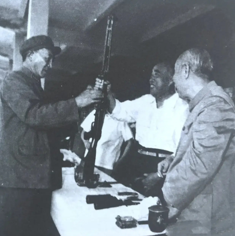 60年代，朱德元帅罕见摸枪的一张照片，罗瑞卿大将在一旁！1964年6月