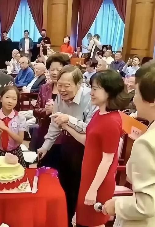 照片中，103岁杨振宁精神气色好，身旁49岁的妻子翁帆，穿红旗袍微笑相伴，想当年