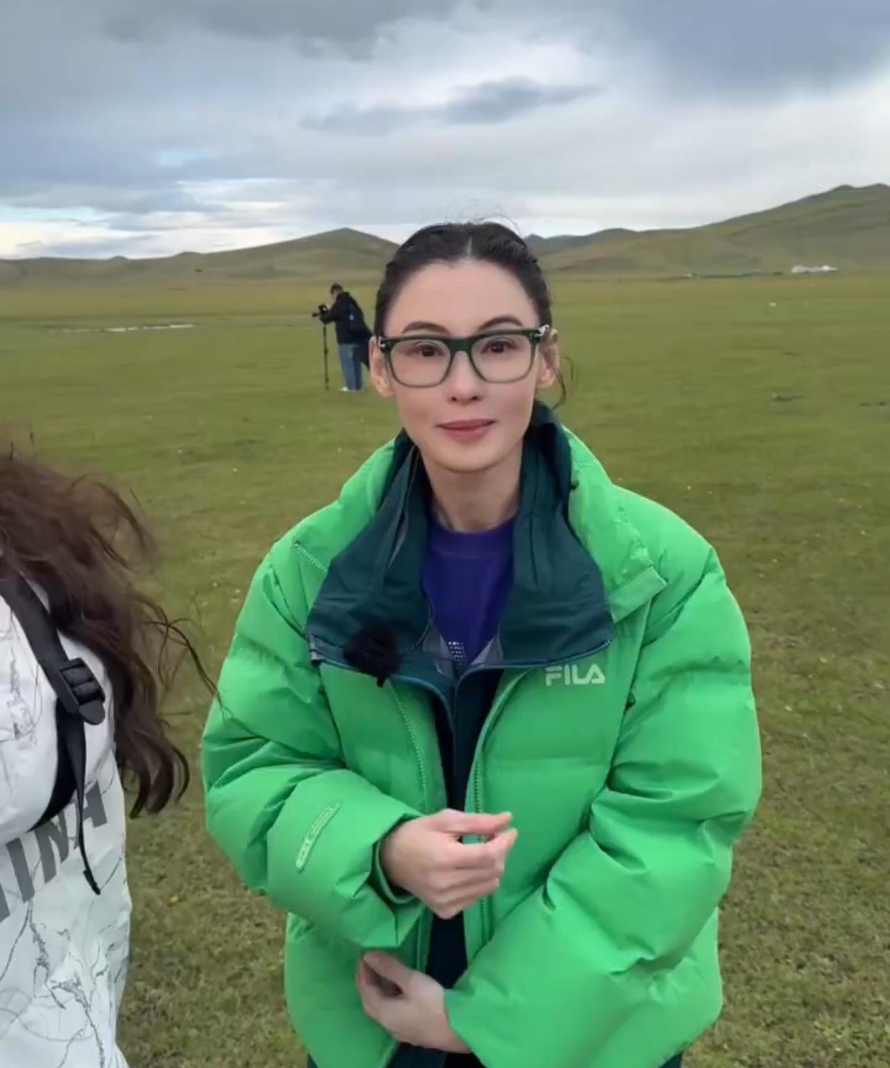 张柏芝去大草原游玩，穿绿色羽绒好惊艳张柏芝在大草原上游玩拍照，穿着绿色羽绒服在