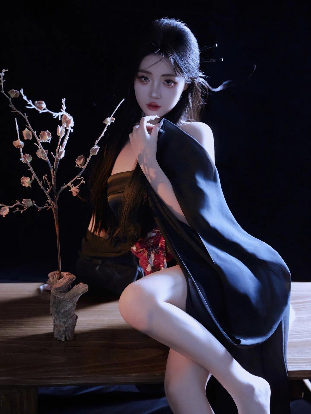 今晚穿了件深蓝色的汉服，光着个脚丫子，画了精致的古风妆容，坐在这个木桌子旁边，是