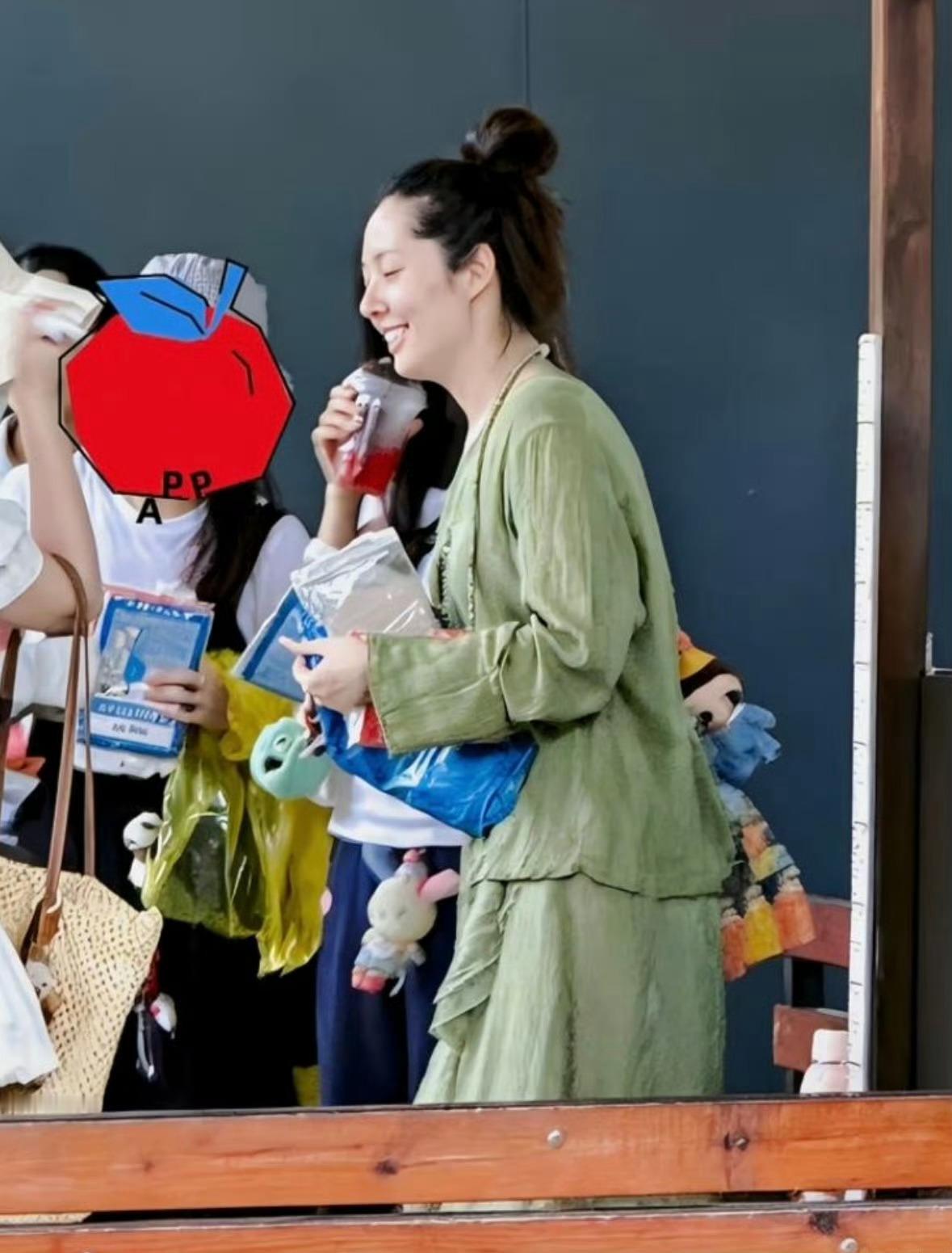 44岁郭碧婷和家人现身西双版纳旅游被偶遇，她穿着一件绿色连衣裙，扎着丸子头，看