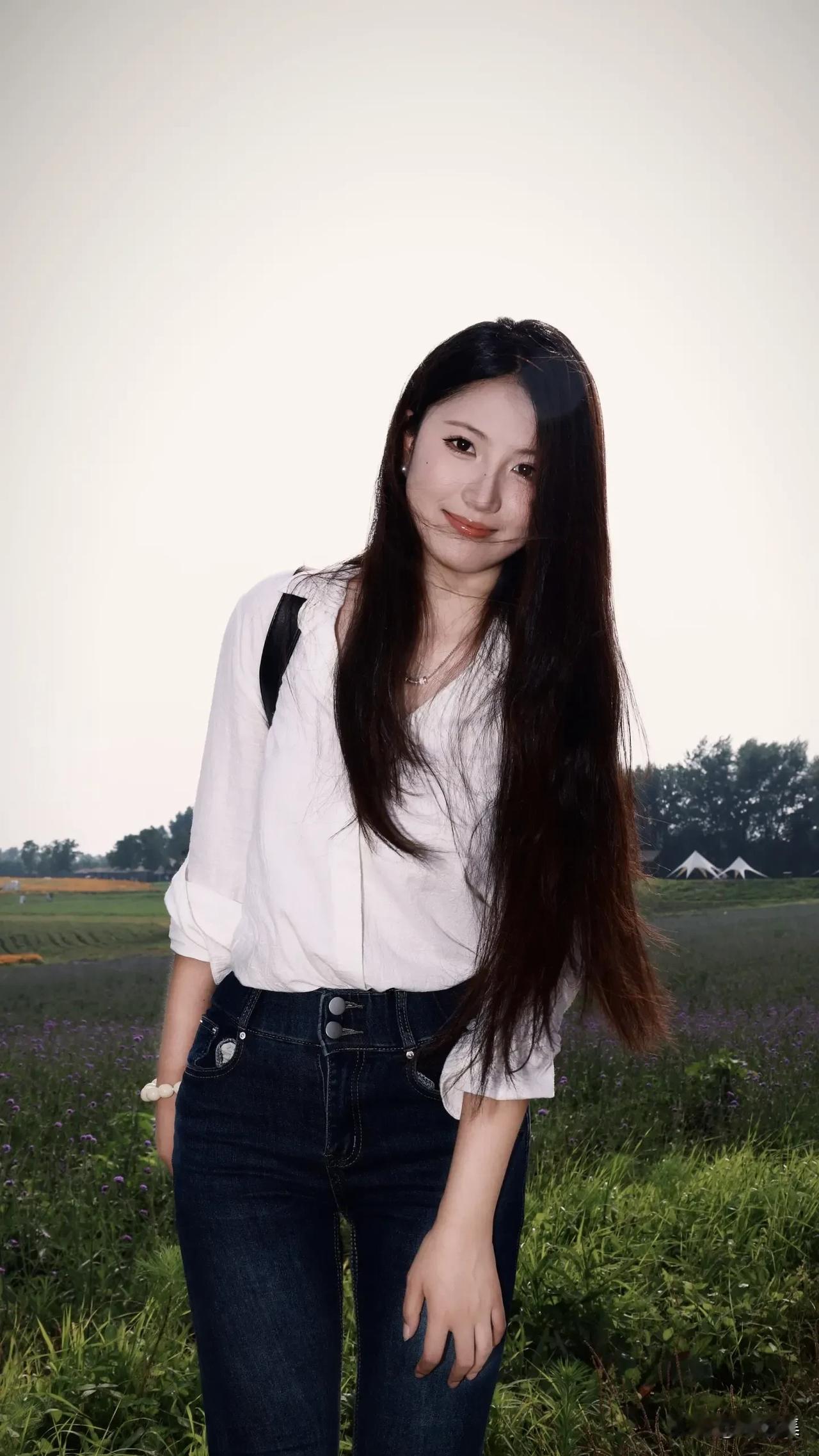 少女在花田中，微笑面对镜头，清新自然。