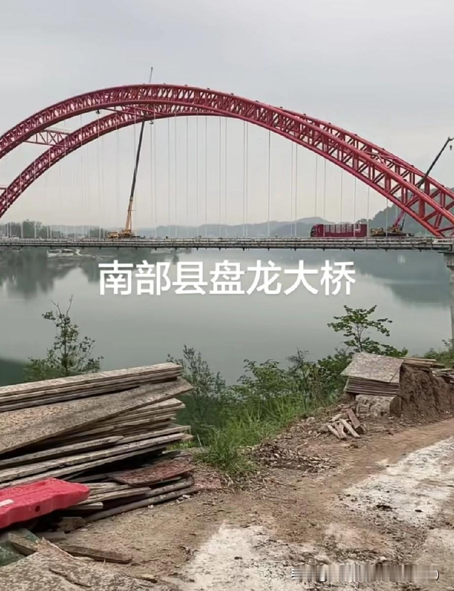 南部盘龙大桥：嘉陵江上的红色长虹，几代人的圆梦之桥远远望去，一道鲜艳的红色