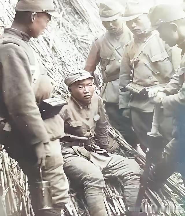 一名抗日小战士坐在秸秆堆上，被数名日军围着，一名日军军官手持军刀俯身逼问！​看