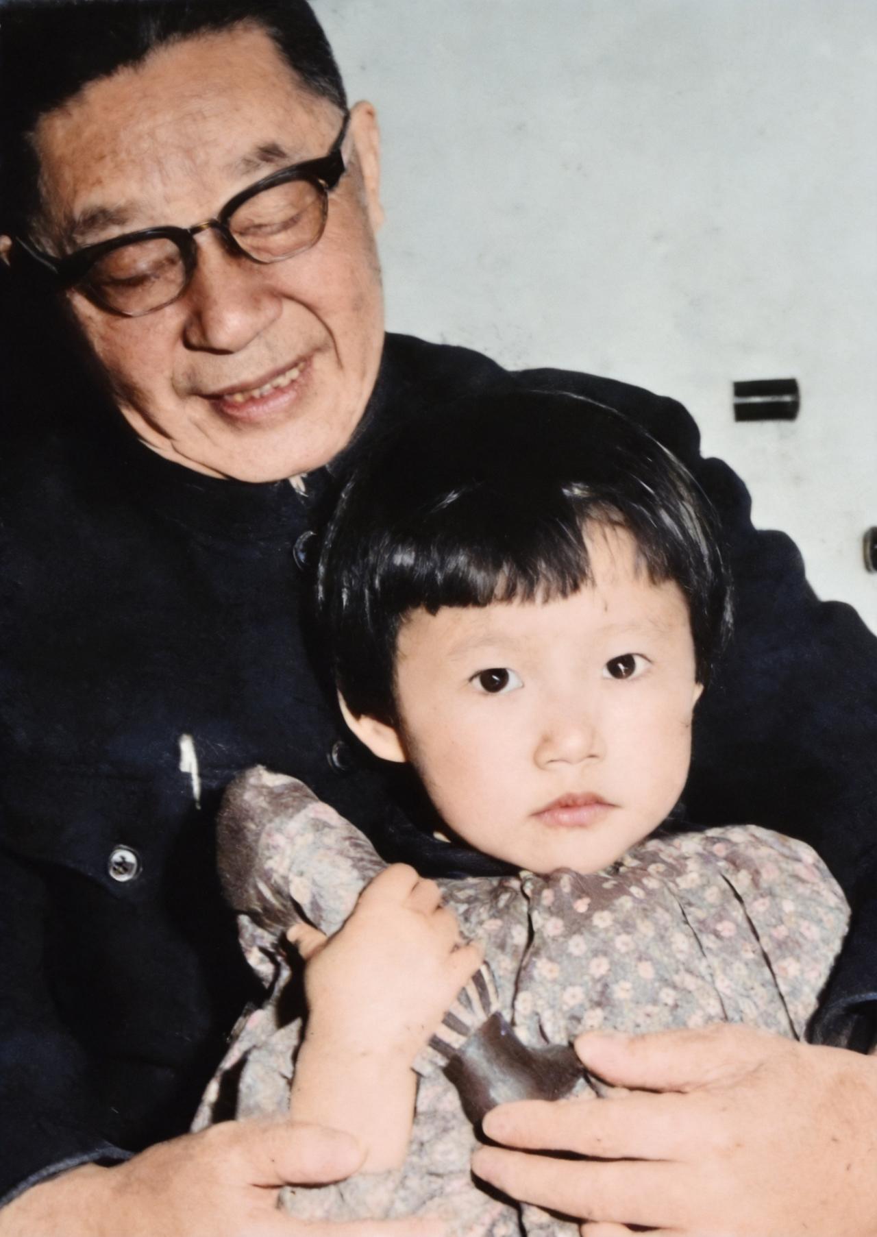 这是1966年1月，老舍抱着小孙女舒悦在家中。老舍在小孙女面前表现出爷爷的慈爱。