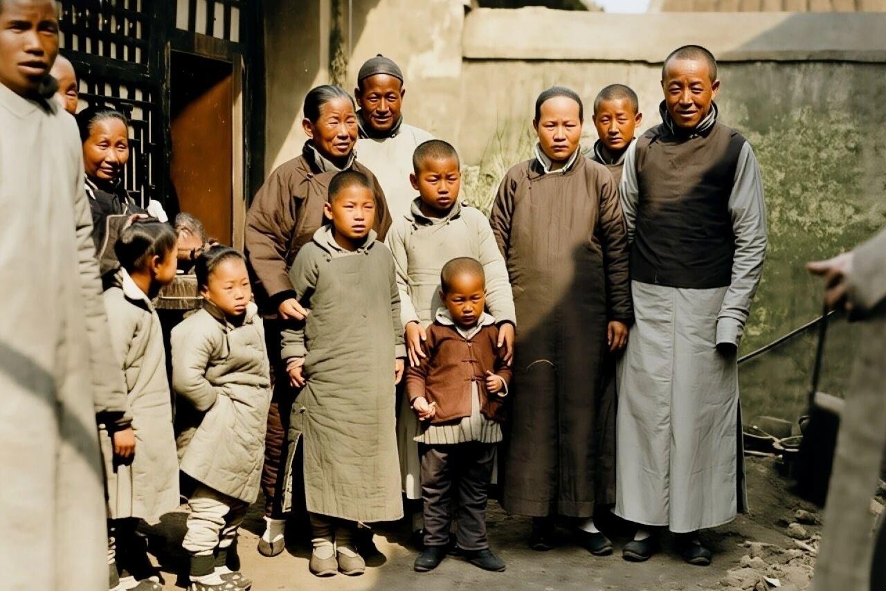 清末，北京一个大户人家13口人的合影。照片中，每个人都穿着长短不一的棉袍，长袍