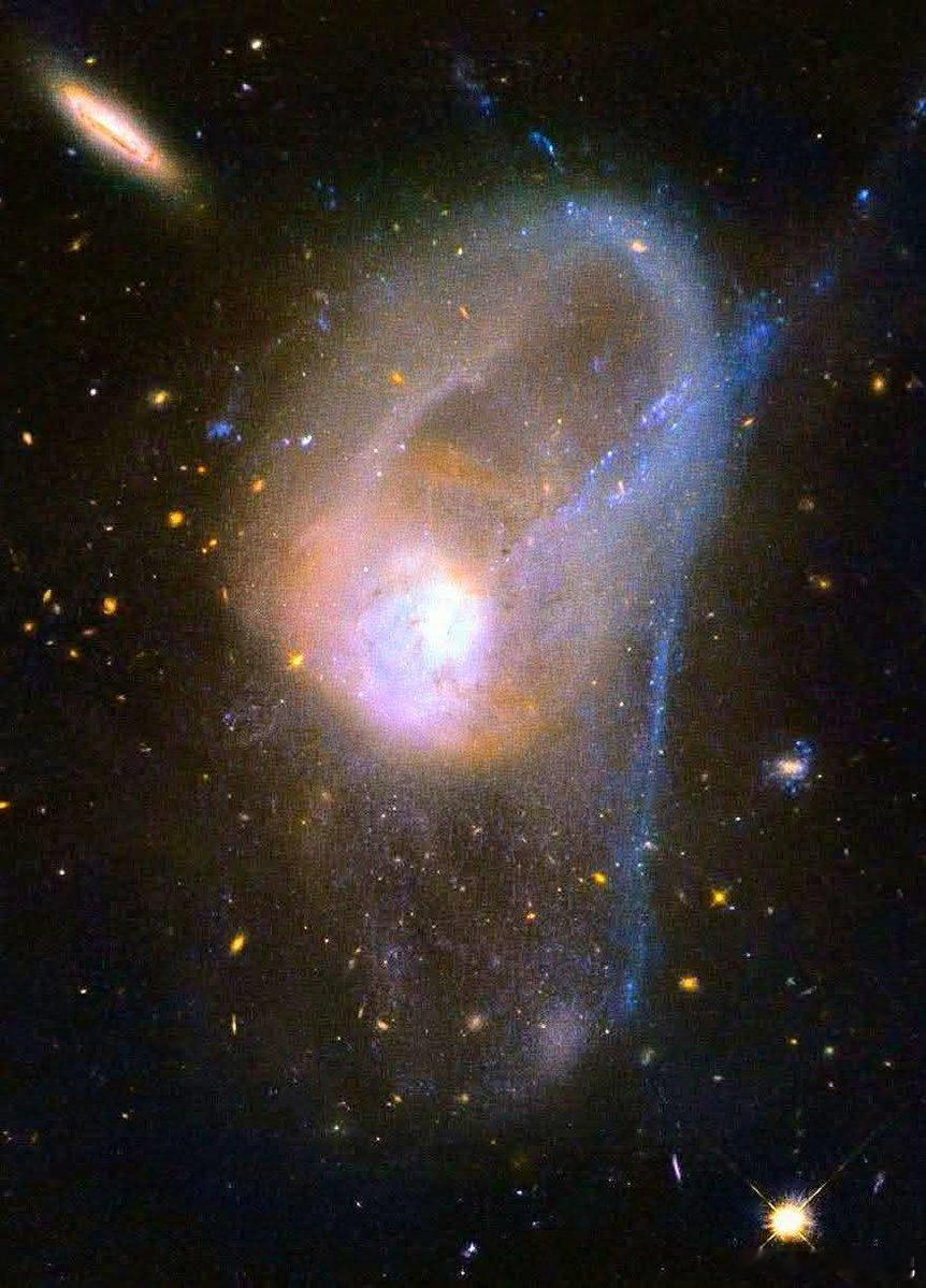 NGC3921并非一颗安静的螺旋星系，自顾自地运转。它是两颗大致质量相当的螺