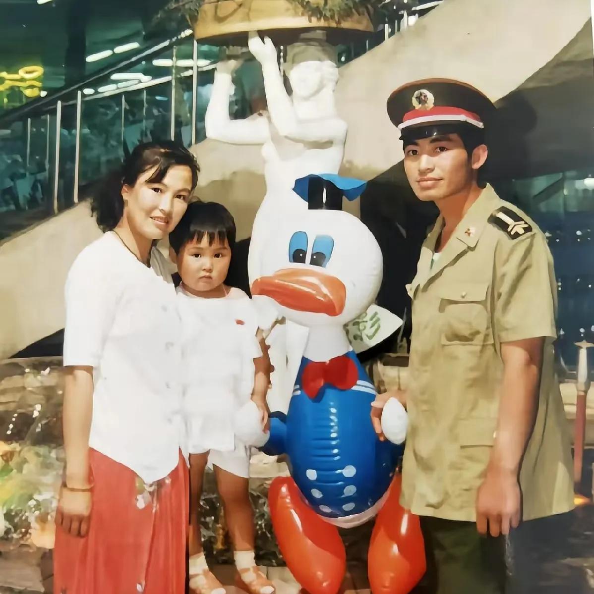 1995年，幸福的军人一家三口。夫妻俩将女儿围在中间，留下了难忘的一瞬。这张照片