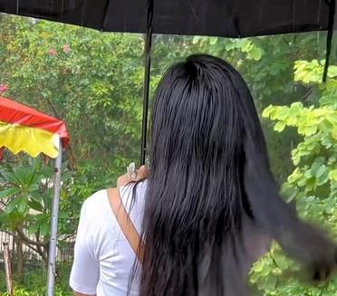 雨天街头，长发的她撑伞漫步，背影透露出一丝忧郁。