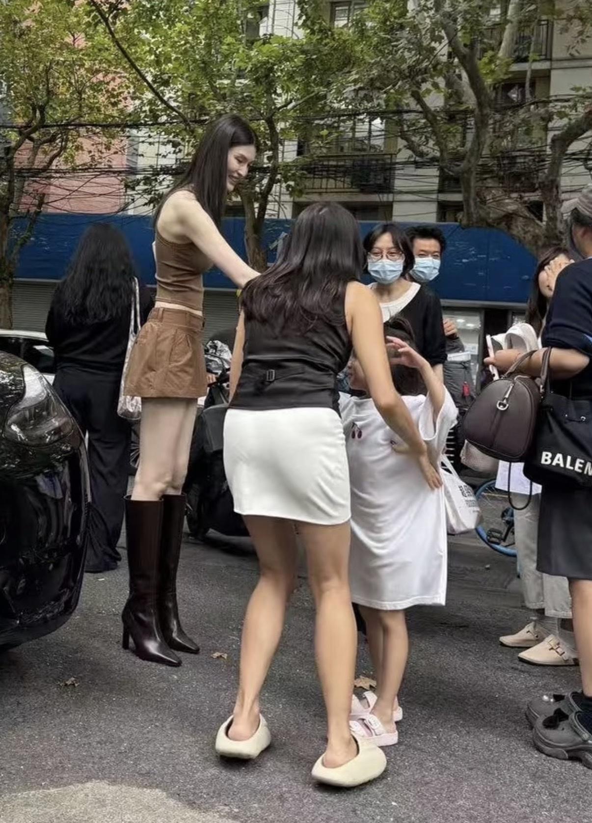 何穗上海街头被偶遇！不愧为超模啊！站在人群中比其他人高一个头！一眼的焦点！站在她