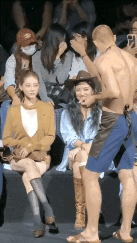 光着膀子的这个外国小伙，不知在对这些具有东方面孔的女孩说着一些什么，他穿的随随便