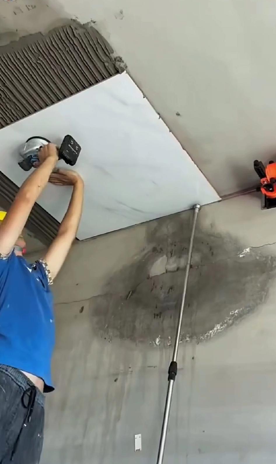 真是艺高胆子大！这位师傅竟把一块块80×80的瓷砖贴到房顶的倒板上。就这手艺，先