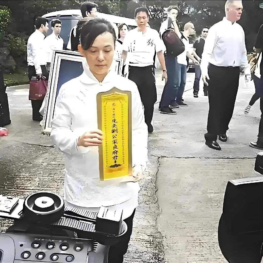 2013年，刘家良出殡仪式，翁静晶捧着丈夫的灵位，一张罕见的留影，照片中的翁静晶