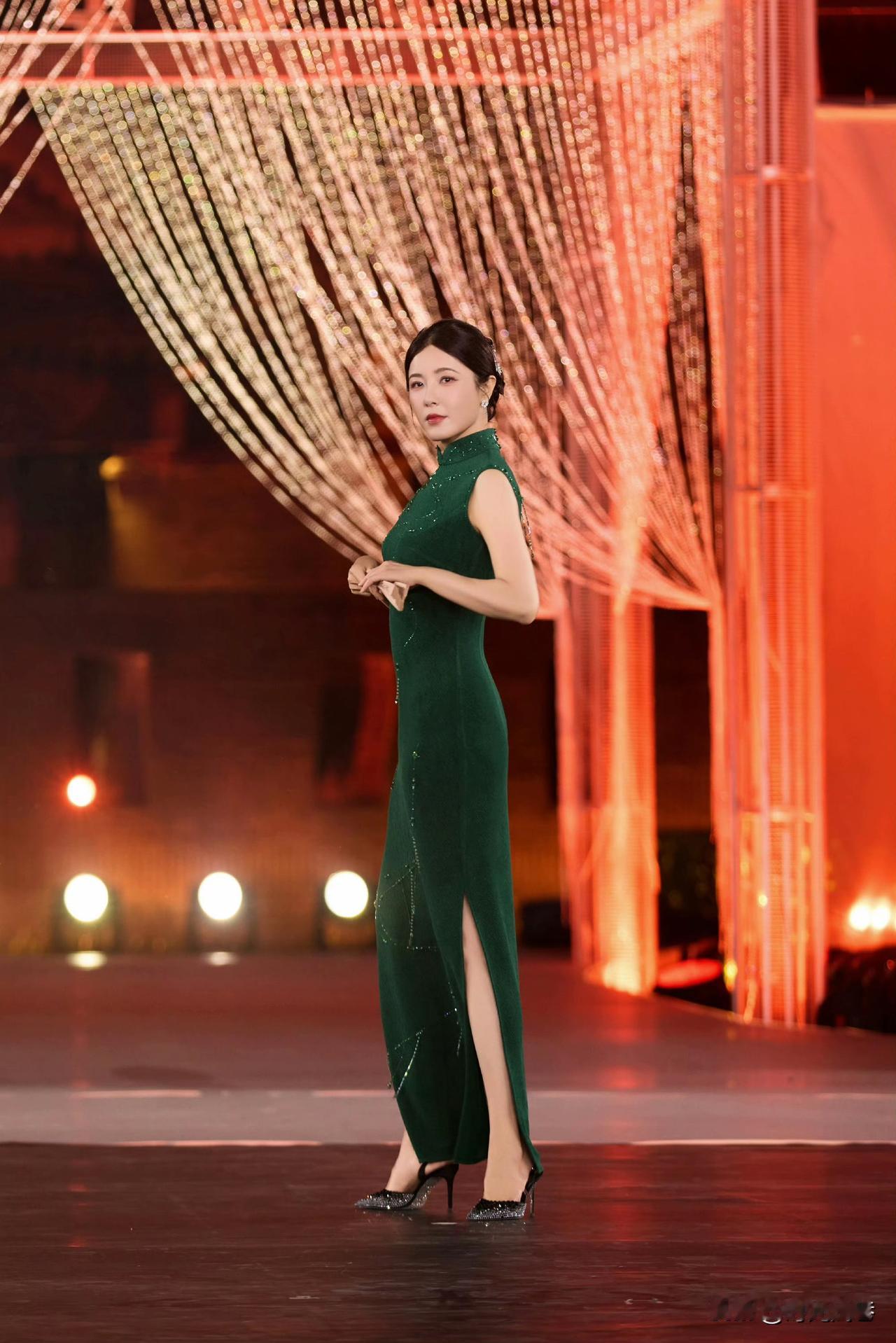 墨绿色紧身旗袍搭配亮闪闪的高跟鞋。曾黎的这套穿搭古典美和现代时尚美相结合。显得亭