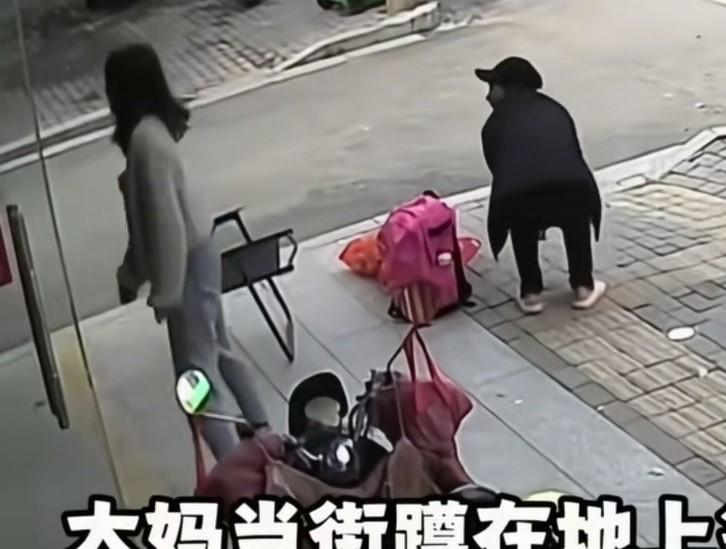 大妈在一店门口前等人，漂亮店主看大妈蹲着很累，就从店里拿了一把椅子出来，让大妈