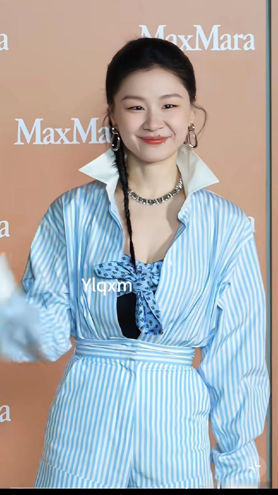 金靖条纹衬衫搭麻花辫亮相活动，她不算明星堆里一眼惊艳的类型，但胜在特别——那张脸