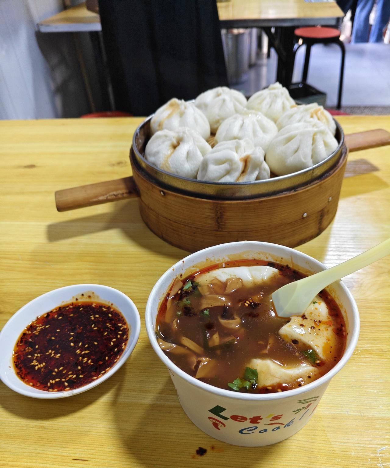 今天的早餐，一屉鲜肉小笼包，外加一豌两掺（就是豆腐脑加胡辣汤），一小碟油辣子拌老