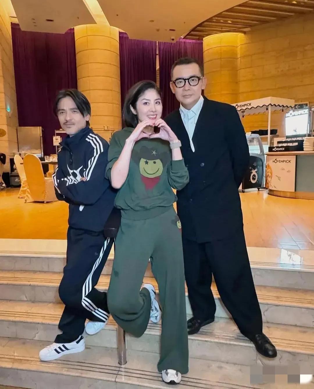 镜头中一身墨绿色套装的陈慧琳皓肤如玉，龙眉凤目，樱唇榴齿，笑容如露；戴着眼镜的雷