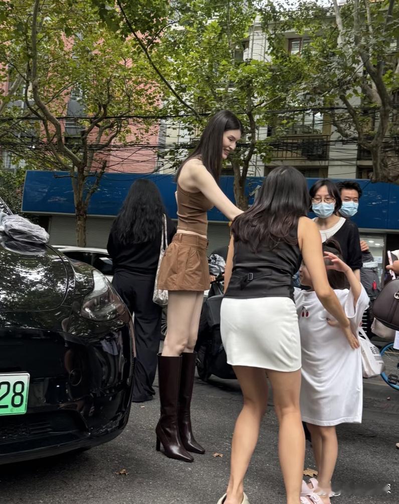 37岁超模何穗在上海街头被偶遇，她穿着小短裙和长筒靴，身材又高又瘦，目测有1.8