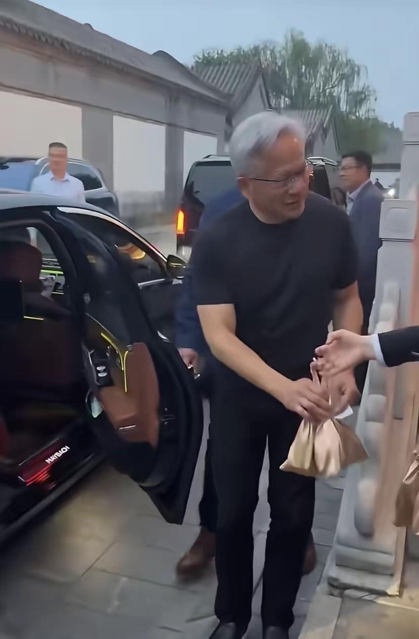 黄仁勋这波接伴手礼的操作，尽显大佬情商！随从见礼吓得连连摆手，他却大方伸手接过，