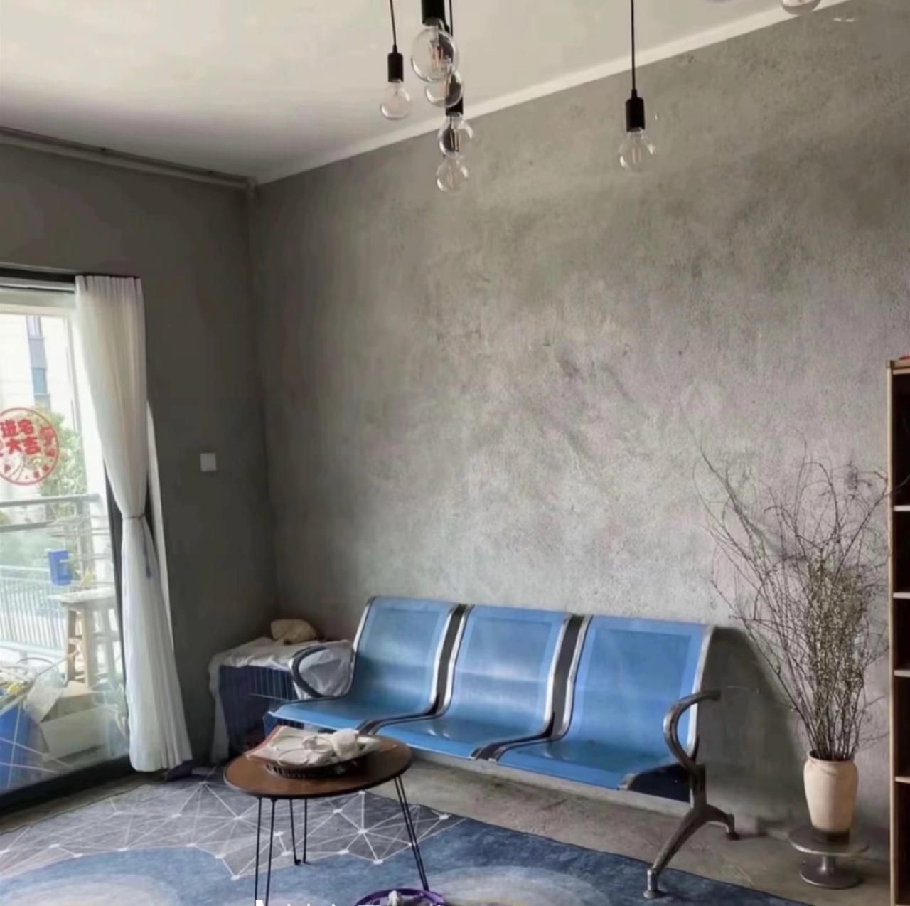 设计风格为“毛坯风”，客厅沙发主打一个实用，夏凉通风，墙面地面粗水泥，吊顶为复古