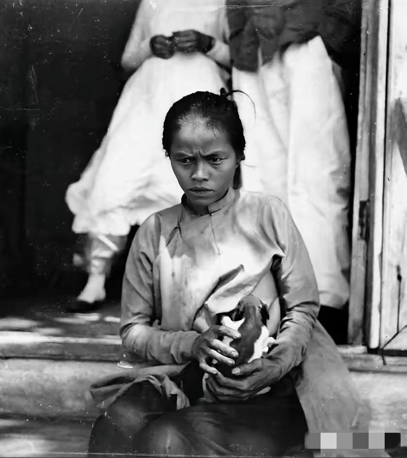 下图，一位越南妇女正在给法国官员的狗喂奶，这张照片拍摄于法国殖民越南期间！