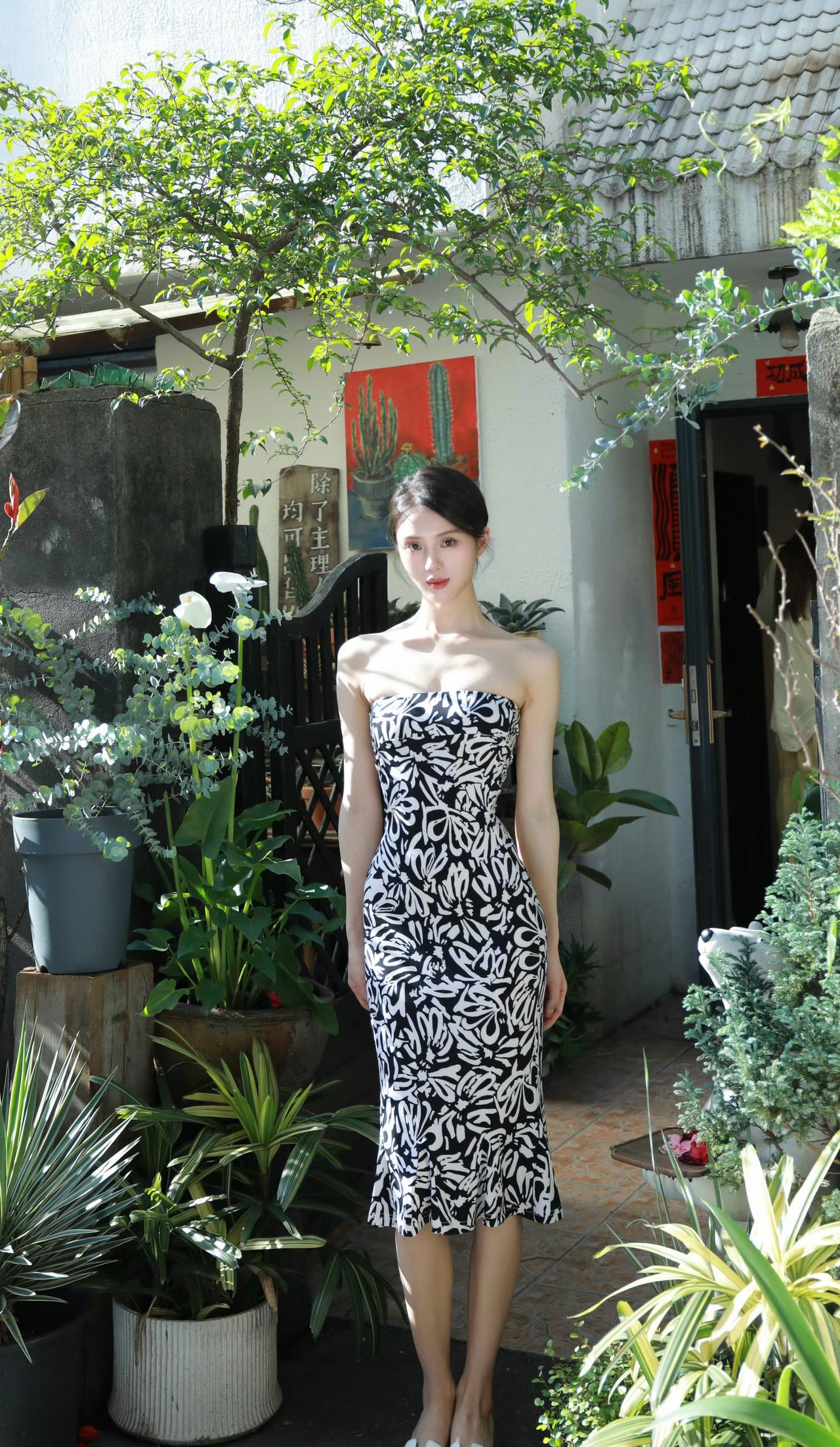 光影在枝叶间流淌，黑白印花裙裹着温柔的风，在庭院的绿意里，酿成一整个慵懒的午后。