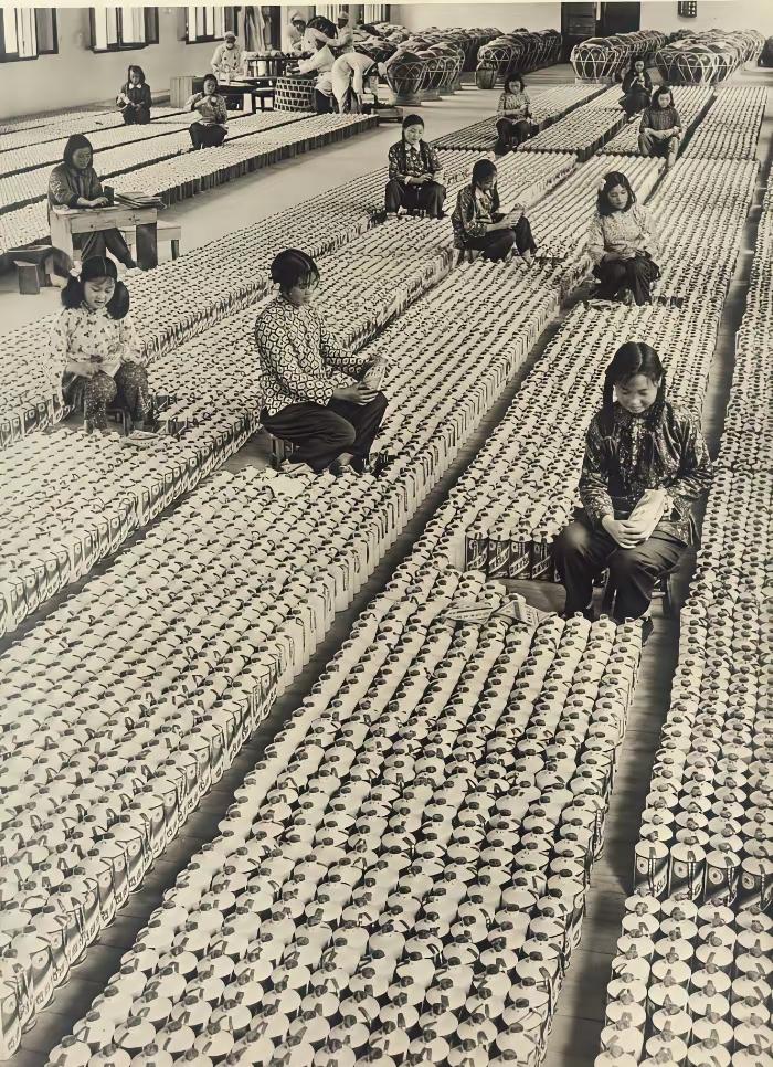1959年，贵州仁怀茅台酒厂包装车间，女工们手工完成茅台酒的裹纸、贴标、包装工序