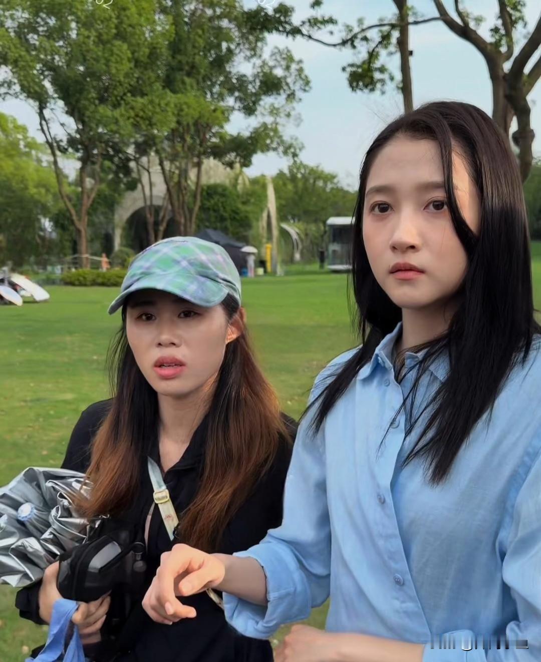 关晓彤无锡拍戏路透的状态绝了！一身浅蓝色衬衫，黑长直发型，站在户外草坪上，周