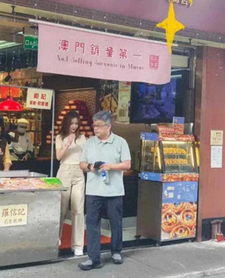杨颖Angelababy在澳门甜品店打工，她站在店门口招呼客人，向客人展示甜品
