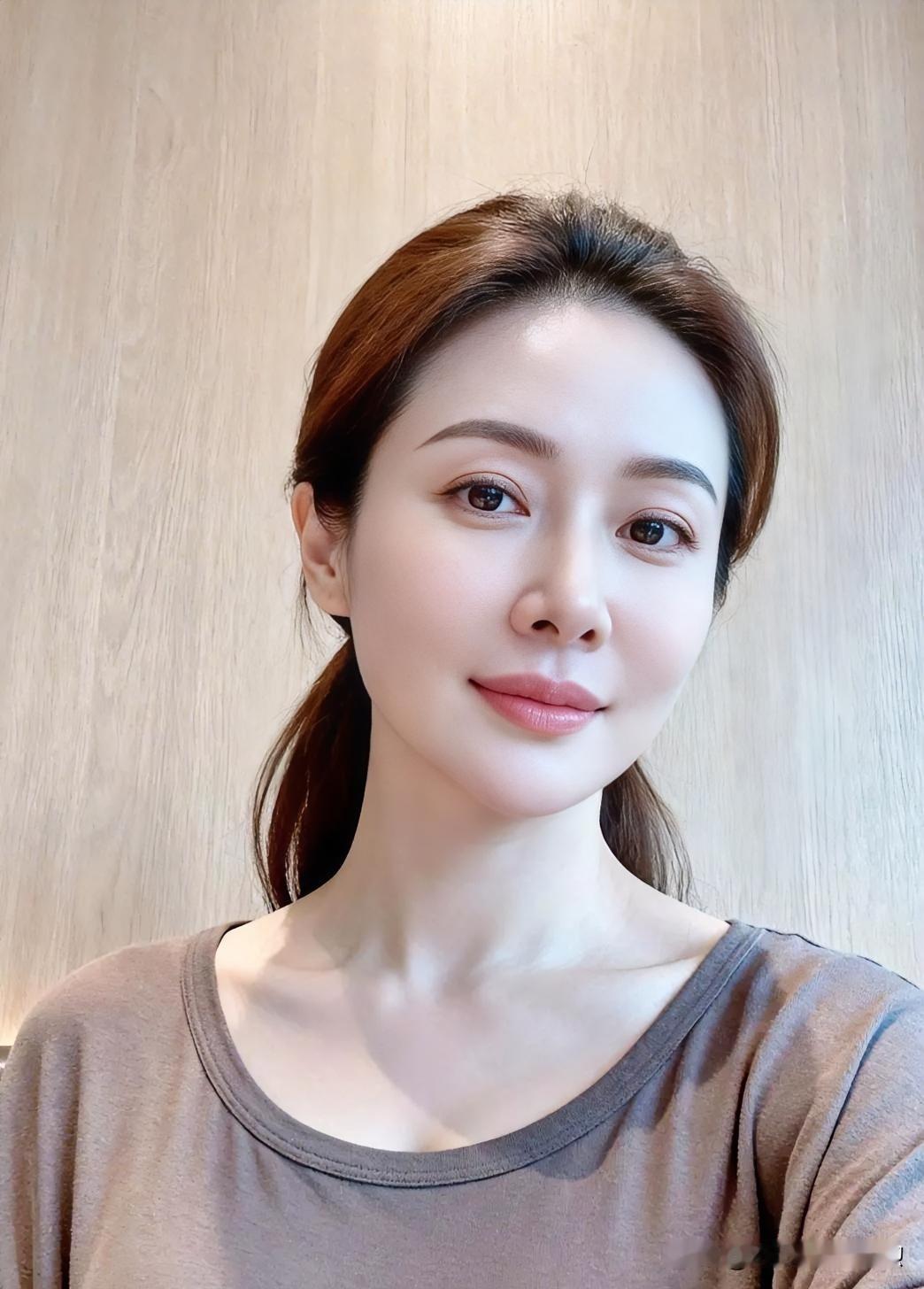 素雅灰棕T恤映衬通透肌肤，低马尾温柔随性。光影流转间，眉眼舒展，尽显日常慵懒之美