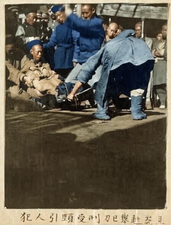 这张照片是晚清北京菜市口刑场的真实记录，它定格了一个生命即将终结的瞬间，一名犯人