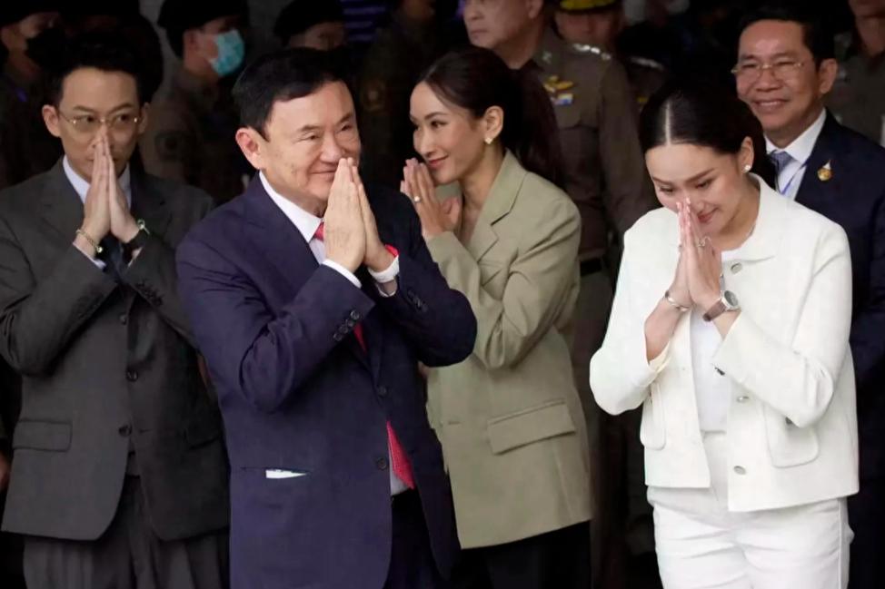 他信一家人双手合十的样子特别的虔诚，他两个女儿笑容好像父亲，亲和力十足。