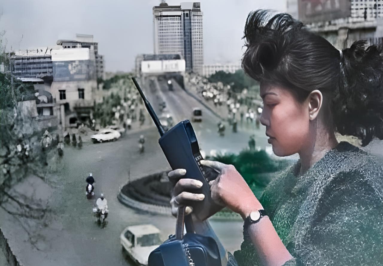 这是1987年广州一名先富起来的女士。这名女士烫着卷发，戴着小手表，手持大哥大。
