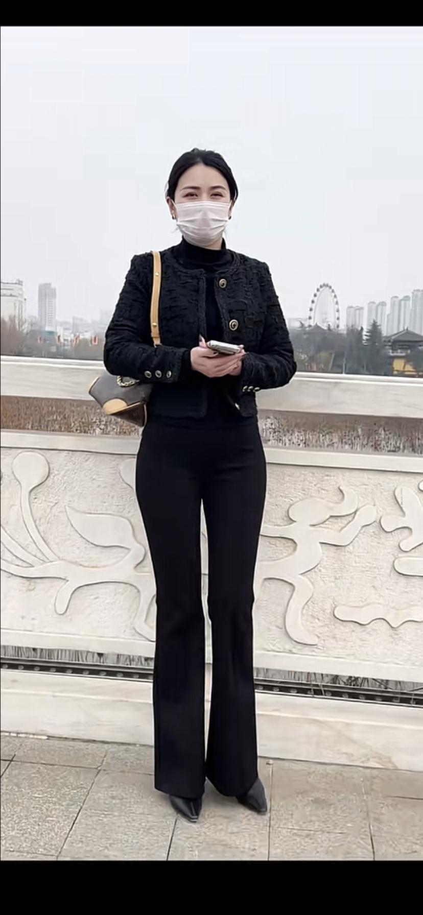 优雅黑衣女子，倚栏远眺，城市天际线尽收眼底。