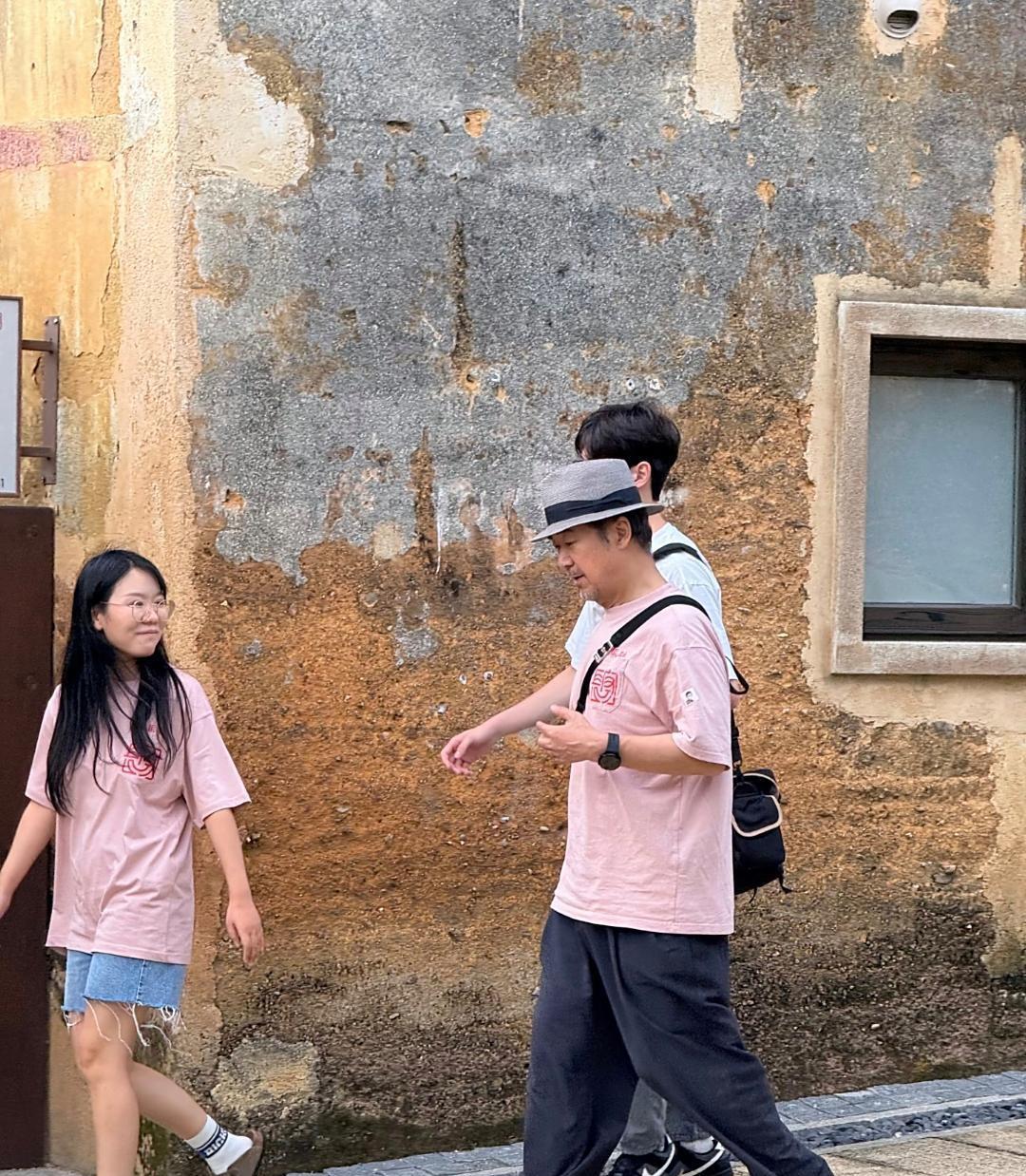 70岁张国立在广东坪山旅游，他穿着粉色T恤，看起来精神抖擞，没有怎么变老，有点矮