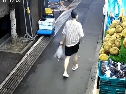 这动作一看就熟，摊主转身称重时，手一探，榴莲被“顺”进胳肢窝，肩膀一抬，边角一挡
