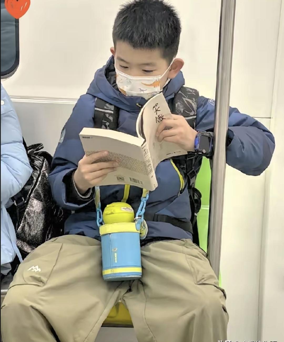 前两天坐地铁上班撞见个有意思的事。后排坐着个小学生模样的，抱着本书看得特别认真。