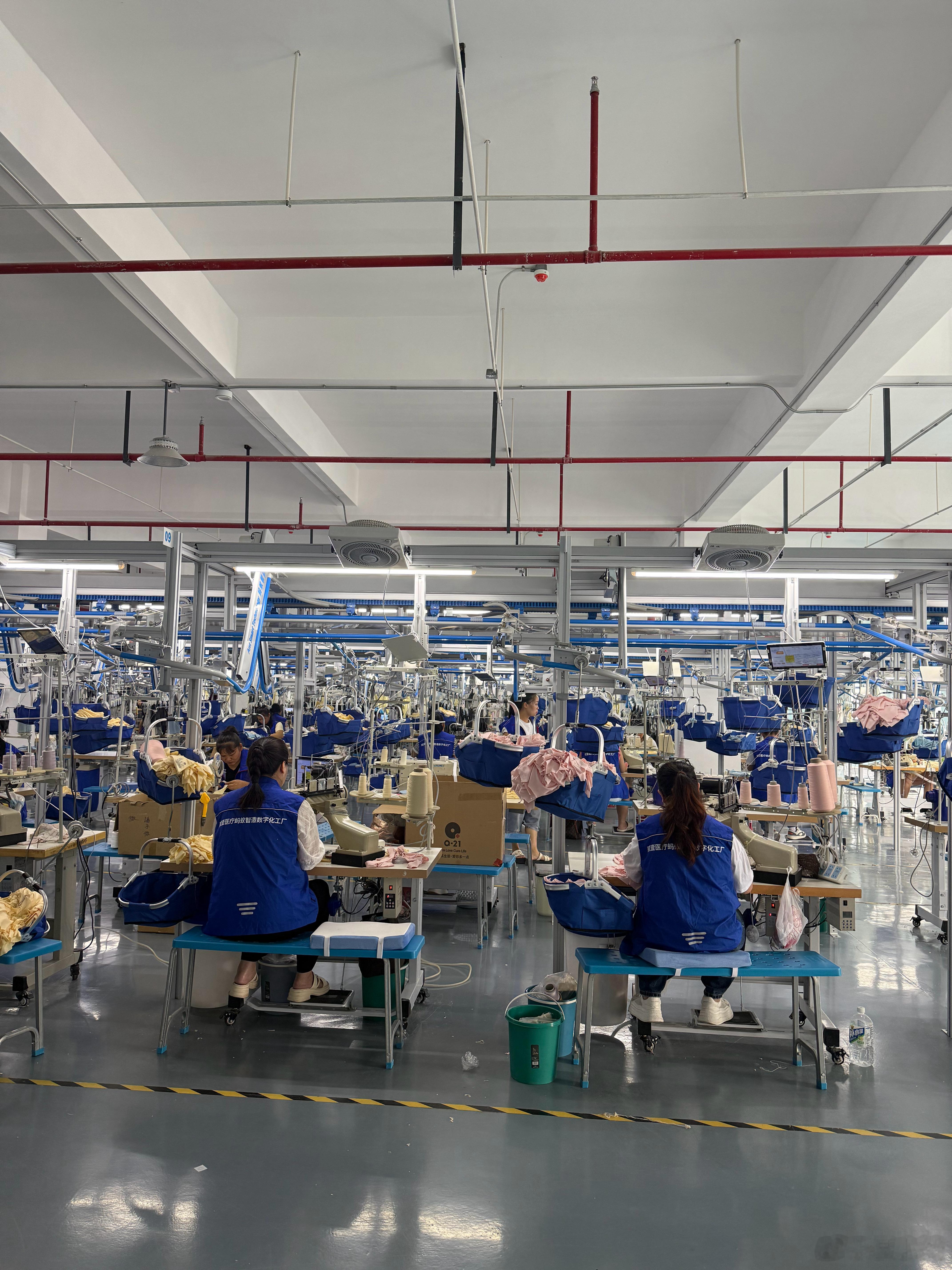 在参观Q21的工厂。现在的服装加工流水线已经全部都是智能化管理了，所有的工序