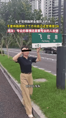 自作聪明！女子散步时，发现路牌特别矮，高度也就刚到她的额头，担心路牌会撞到行人的