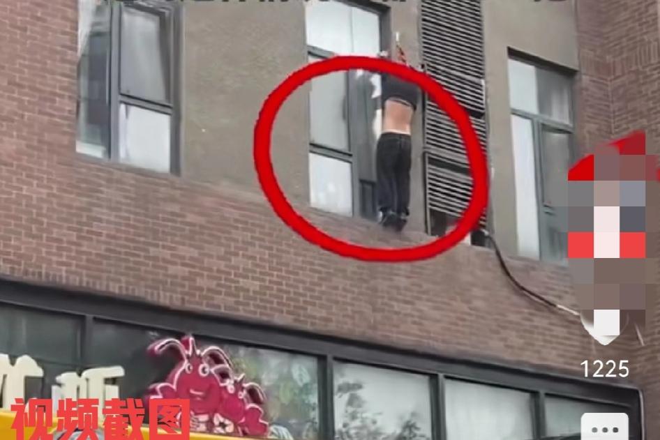 有工人在一处小区内拆空调。此刻工人由于一个不留神不慎跌落半空，被安全绳索套紧