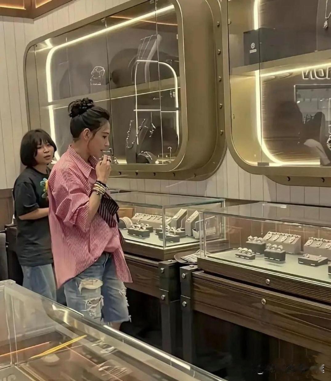 46岁张柏芝现身三亚周大福门店。她穿粉条纹衬衫搭破洞牛仔裤。头发盘得利落，皮肤紧又有光泽。状态看起来
