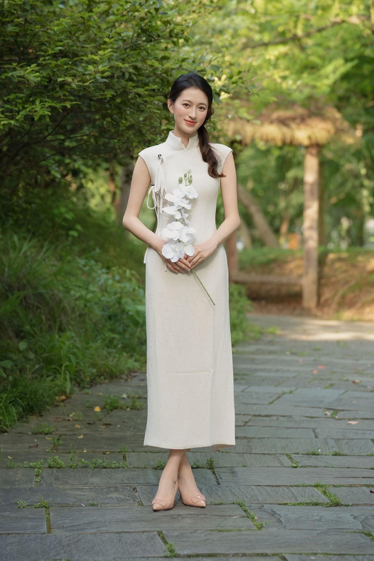 女人味十足，体现在哪里绿林曲径，素色旗袍映佳人，一花在手，自有恬淡温婉的东方风骨